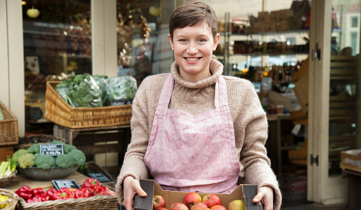 Woman holding box of apples